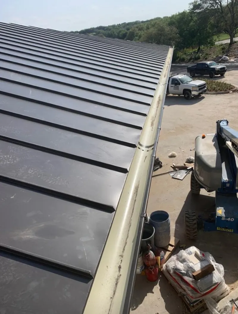 Standing seam panel and gutter detail on a metal roofing jobsite in Tahlequah